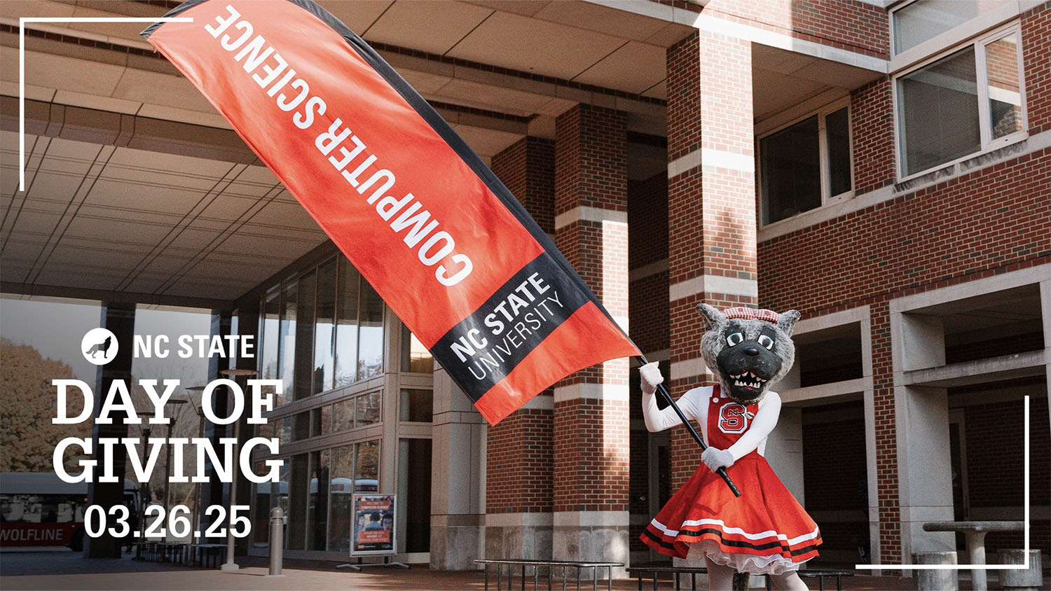 A costumed mascot with a wolf-like head and gray fur, wearing a red dress with white trim and the number "S" on the bodice, holds a large red banner. The banner reads "COMPUTER SCIENCE" vertically in white text, and "NC STATE UNIVERSITY" horizontally in white text on a black background. The mascot is standing outdoors in front of a brick building with many windows. Text overlaid on the image says "NC STATE DAY OF GIVING" and "03.26.25".
